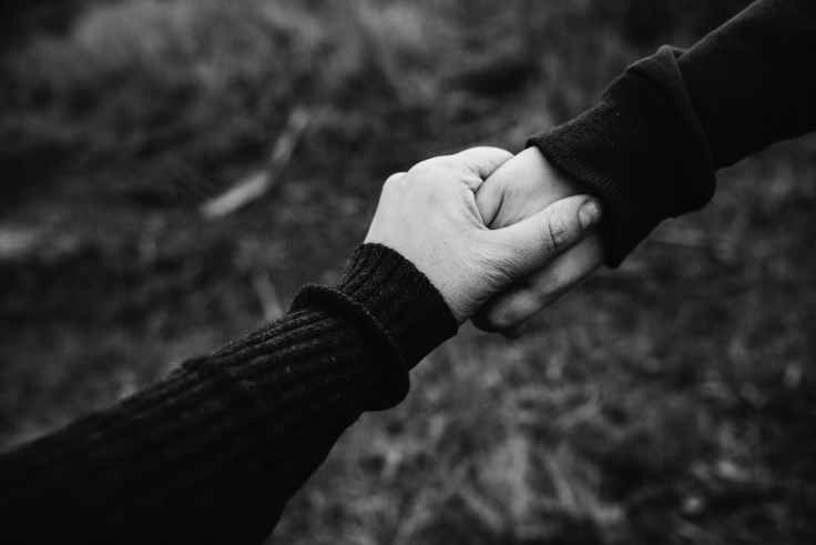 black and white photo of holding hands